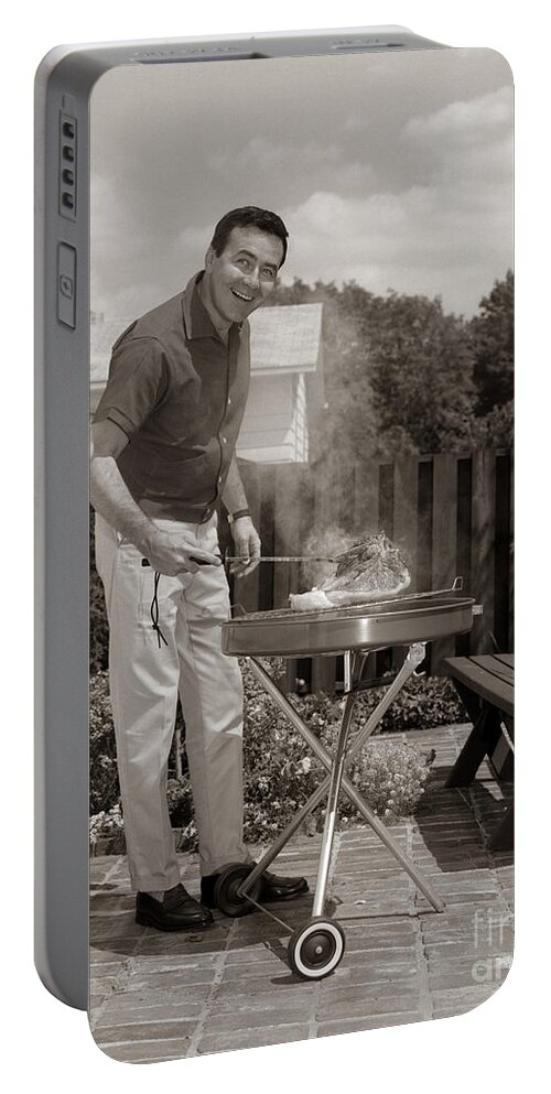 1960s Portable Battery Charger featuring the photograph Man Grilling In Backyard, C.1960s by H. Armstrong Roberts/ClassicStock