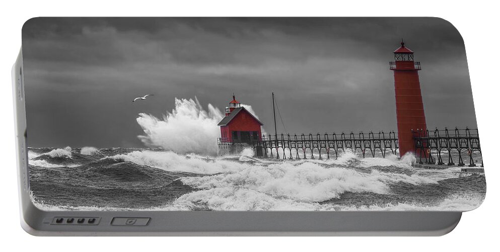 Lighthouse Portable Battery Charger featuring the photograph November Storm with Flying Gull by the Grand Haven Lighthouse by Randall Nyhof