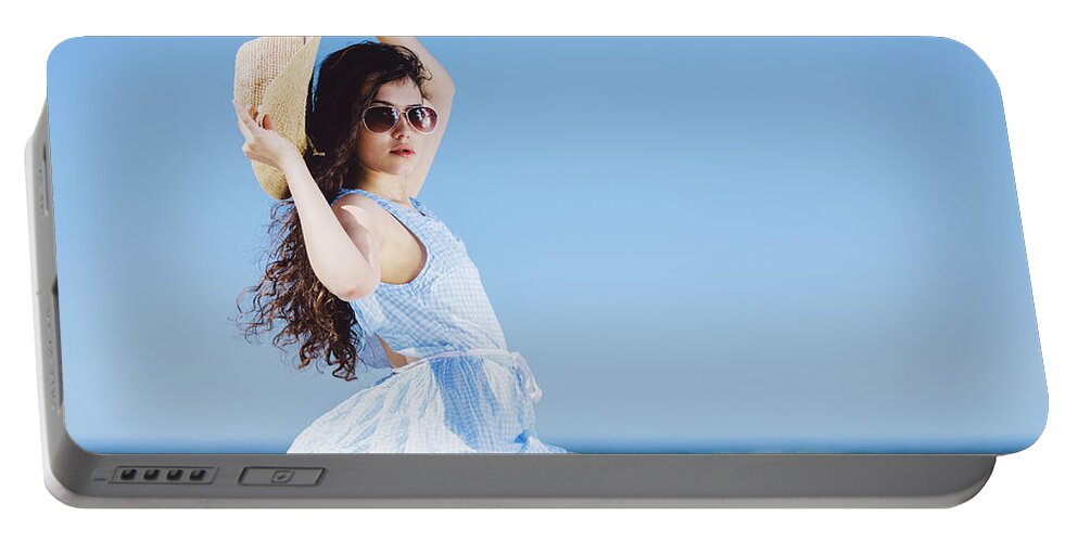Woman Portable Battery Charger featuring the photograph Pretty girl sitting on a sandy beach by the blue sea. by Michal Bednarek