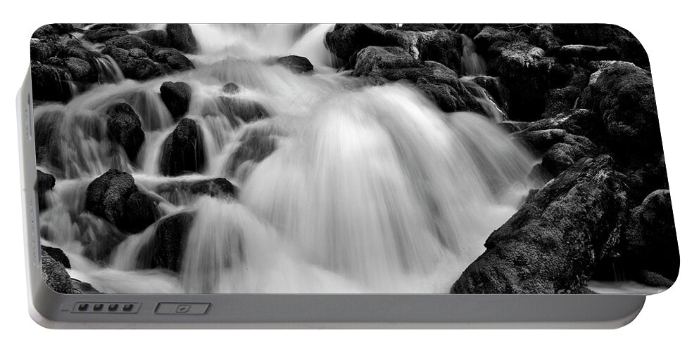 Stream Portable Battery Charger featuring the photograph Spring waterfall over mossy rocks in black and white by Bruce Block