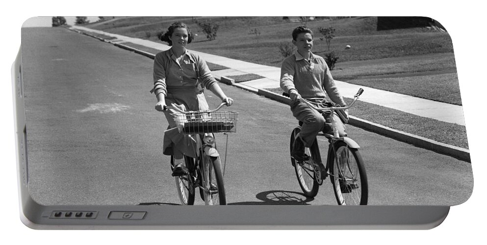 1950s Portable Battery Charger featuring the photograph Teen Boy And Girl Riding Bikes, C.1950s by H. Armstrong Roberts/ClassicStock