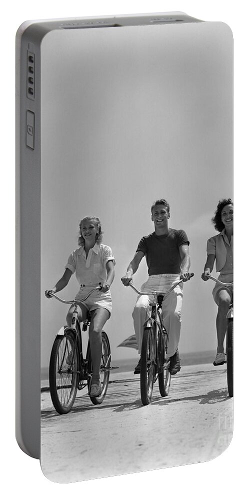 1940s Portable Battery Charger featuring the photograph Young People Biking On The Beach by H Armstrong Roberts and ClassicStock