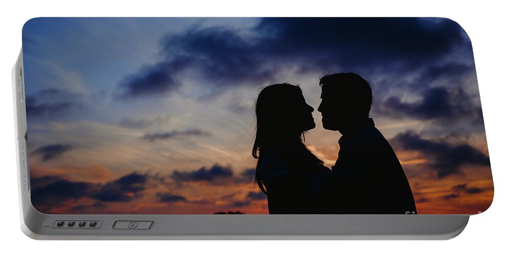 Background Portable Battery Charger featuring the photograph Couple with cloud sky backlight #1 by Joaquin Corbalan