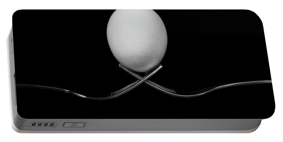 Egg Portable Battery Charger featuring the photograph White egg resting on two metal and shiny forks on a black backg by Michalakis Ppalis