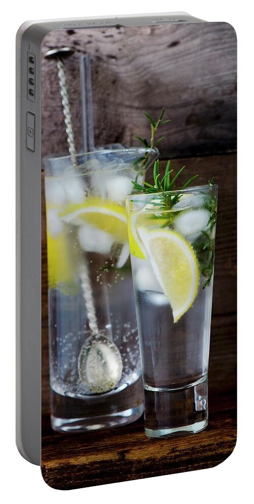 Ip_12312619 Portable Battery Charger featuring the photograph Gin And Tonic With Lemon, Ice Cubes And Rosemary by Jamie Watson