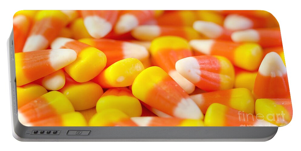 Halloween Portable Battery Charger featuring the photograph Macro closeup of Halloween traditional Candy Corn treats. by Milleflore Images