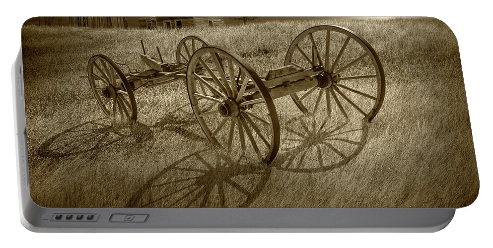 Farm Portable Battery Charger featuring the photograph Sepia Tone Photograph of a Farm Wagon Chassis in a Grassy Field by Randall Nyhof