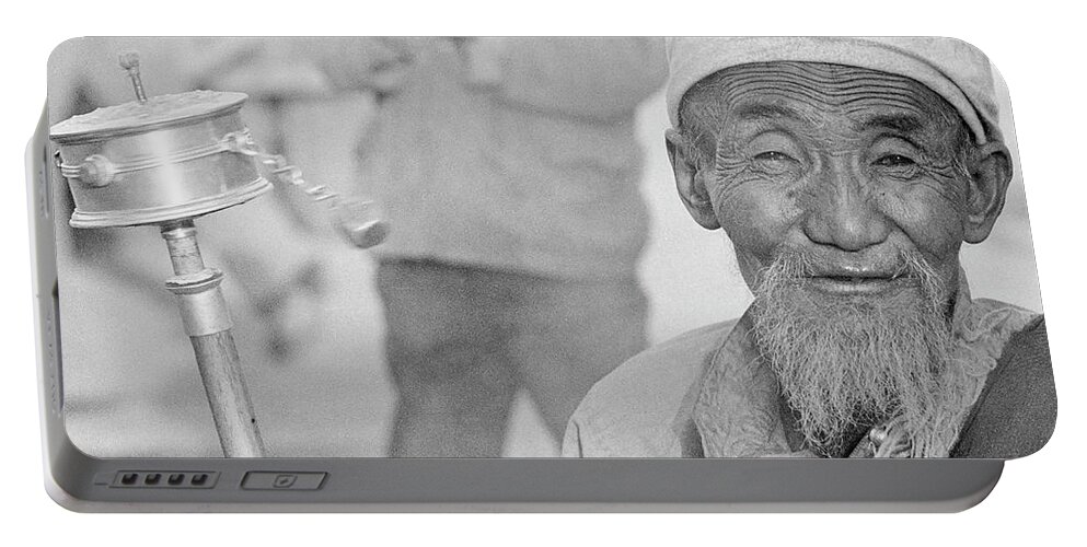 Tibet Portable Battery Charger featuring the photograph Tibetan man with prayer wheel by Neil Pankler