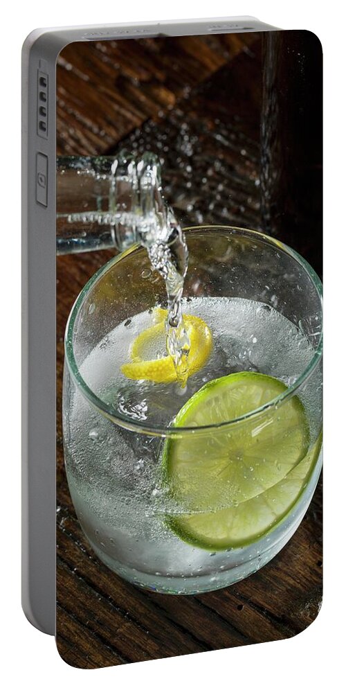 Ip_11339069 Portable Battery Charger featuring the photograph Tonic Water Being Poured Into A Glass Of Gin by Don Crossland