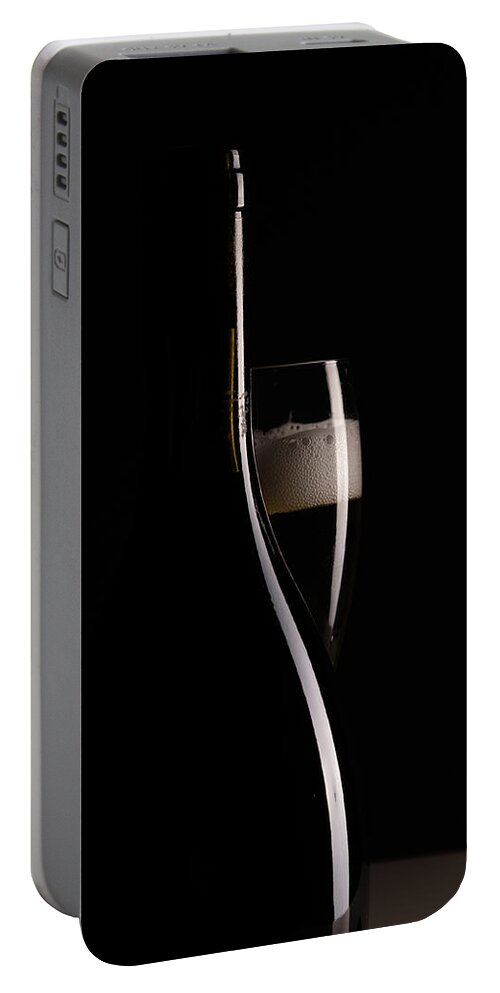 Red Wine Portable Battery Charger featuring the photograph Red sparking wine on a wineglass and black wine bottle. by Michalakis Ppalis