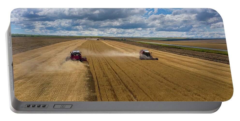 Agriculture Portable Battery Charger featuring the photograph Aerial view of combine on harvest field by Mikhail Kokhanchikov