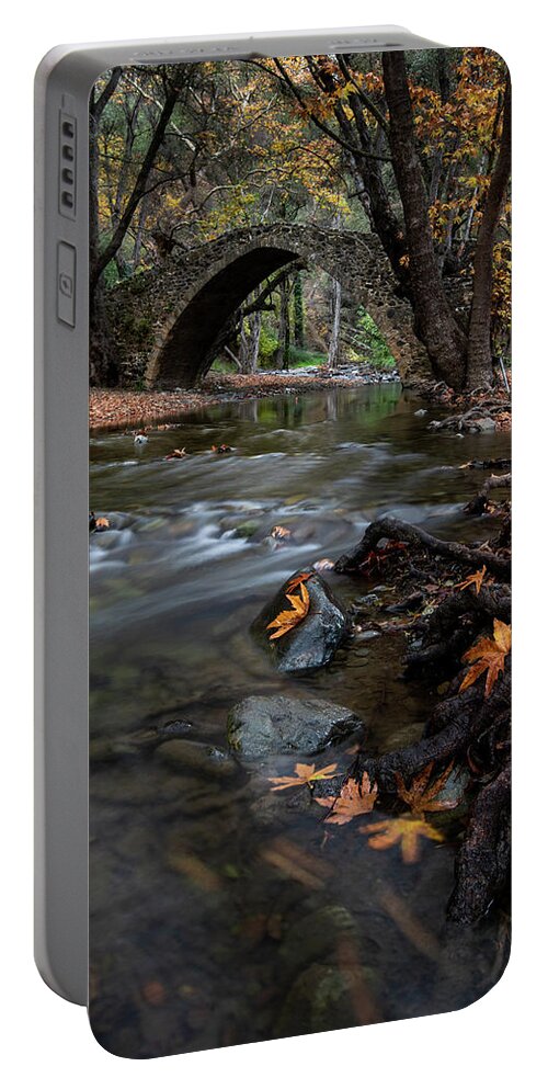 Autumn Portable Battery Charger featuring the photograph Autumn landscape with river flowing under a stoned bridge by Michalakis Ppalis