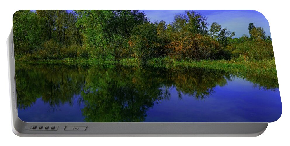 Reflection Portable Battery Charger featuring the photograph Blue sky and trees reflected in still water by Jeff Swan