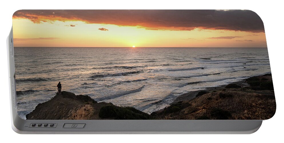 Sea Portable Battery Charger featuring the photograph Couple hugging at the edge of a cliff during a dramatic sunset by Michalakis Ppalis