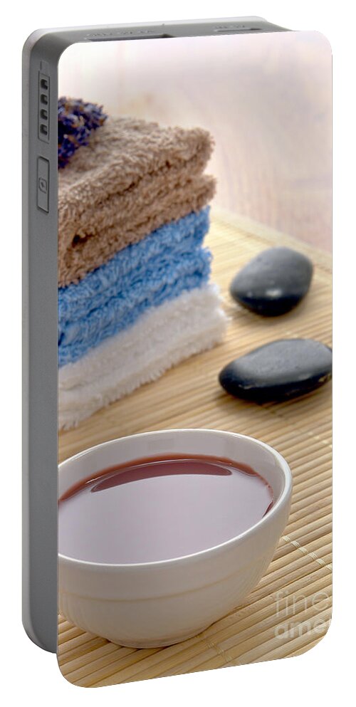 Black Portable Battery Charger featuring the photograph Hot Massage Oil with Polished Stones and Towels in a Spa by Olivier Le Queinec