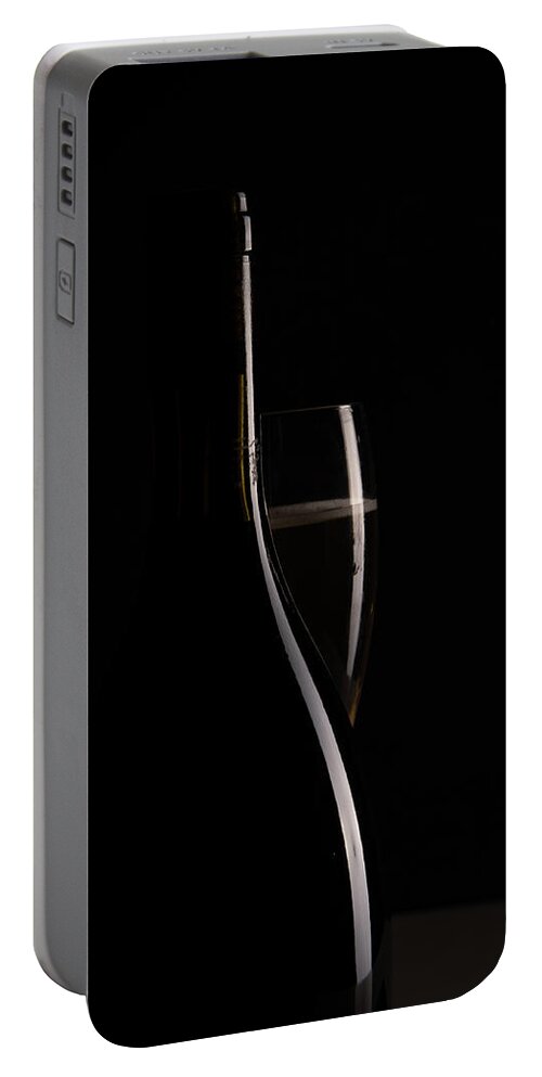 Red Wine Portable Battery Charger featuring the photograph Red sparking wine on a wineglass and black wine bottle. by Michalakis Ppalis