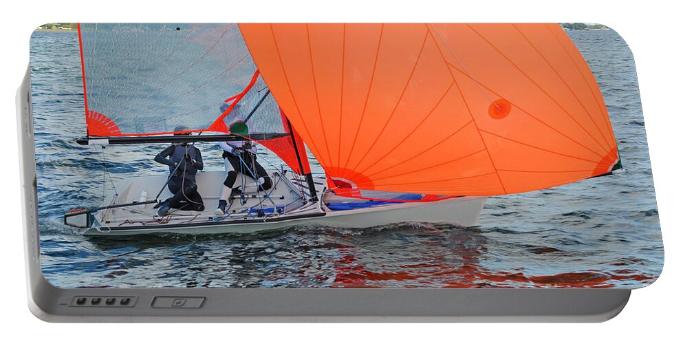 Landscape Portable Battery Charger featuring the photograph Two children sailing a racing dinghy with a large fully deployed by Geoff Childs