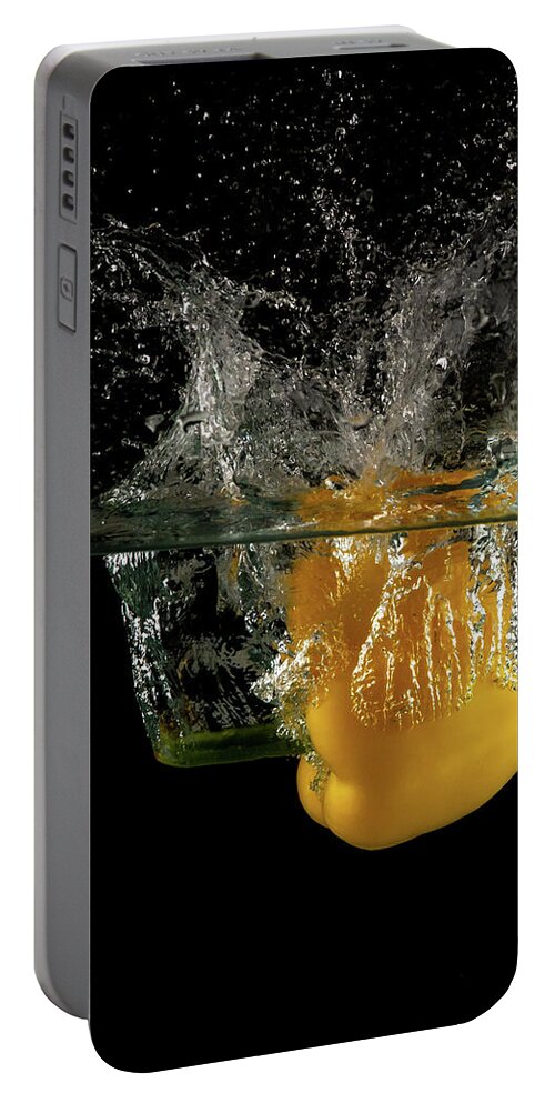 Pepper Portable Battery Charger featuring the photograph Yellow bell pepper dropped and slashing on water by Michalakis Ppalis