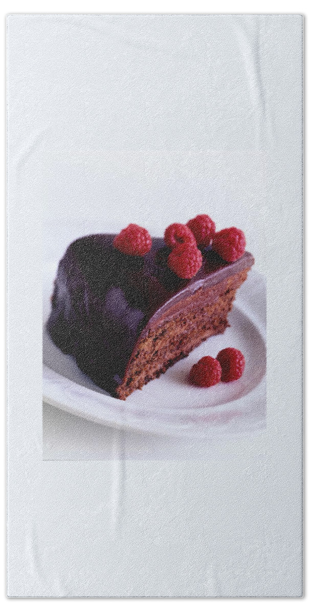 A Chocolate Pecan Cake With Raspberries On Top Beach Towel