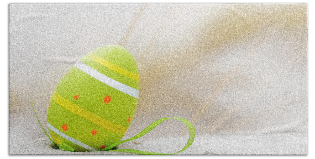 Easter Beach Towel featuring the photograph Easter decorated egg on sand by Michal Bednarek