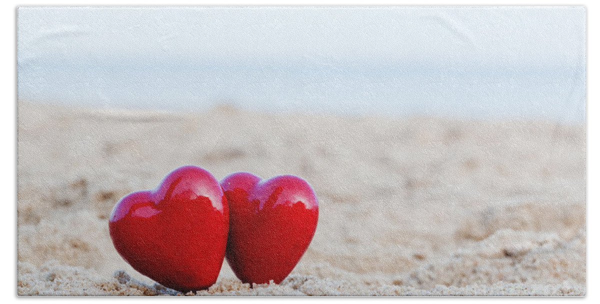 Heart Beach Sheet featuring the photograph Two red hearts on the beach symbolizing love by Michal Bednarek