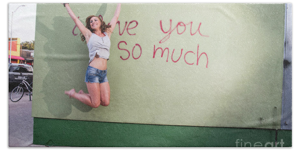 I Love You So Much Beach Towel featuring the photograph Attractive Austin local woman jumps for joy at the i love you so much mural by Dan Herron