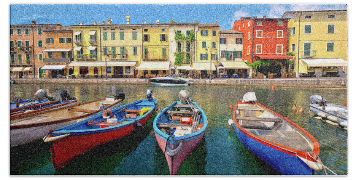 Lazise Beach Towel featuring the photograph Lazise colorful harbor and boats view by Brch Photography
