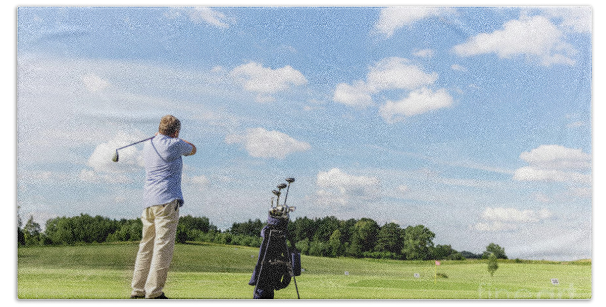 Golf Beach Towel featuring the photograph Senior fit man hitting a golf ball. by Michal Bednarek