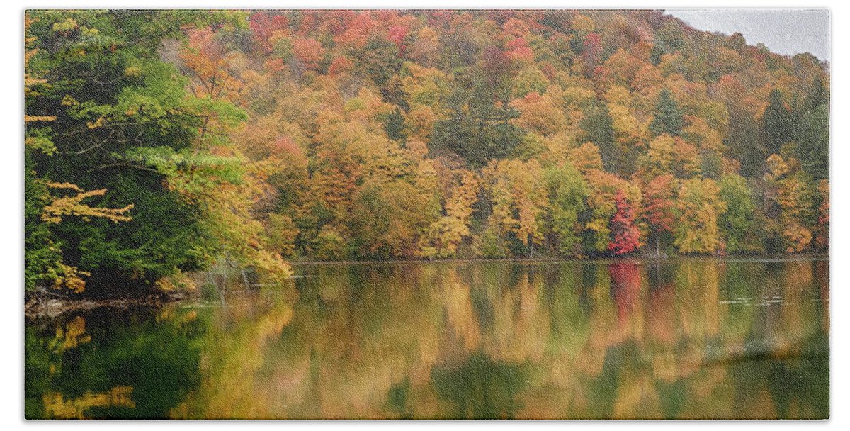 Abenaki Beach Towel featuring the photograph Vermont fall foliage reflected on Pogue Pond by Jeff Folger
