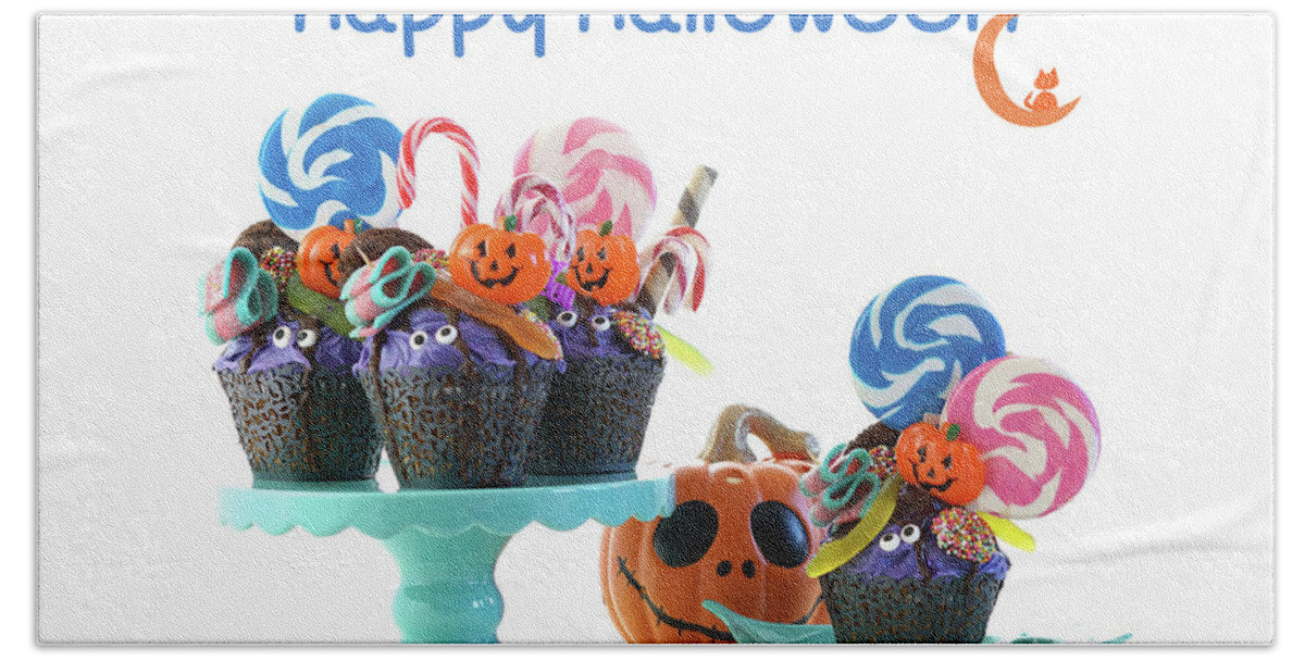 Halloween Beach Towel featuring the photograph Halloween candyland drip cake style cupcakes with lollipops and candy on white. #1 by Milleflore Images