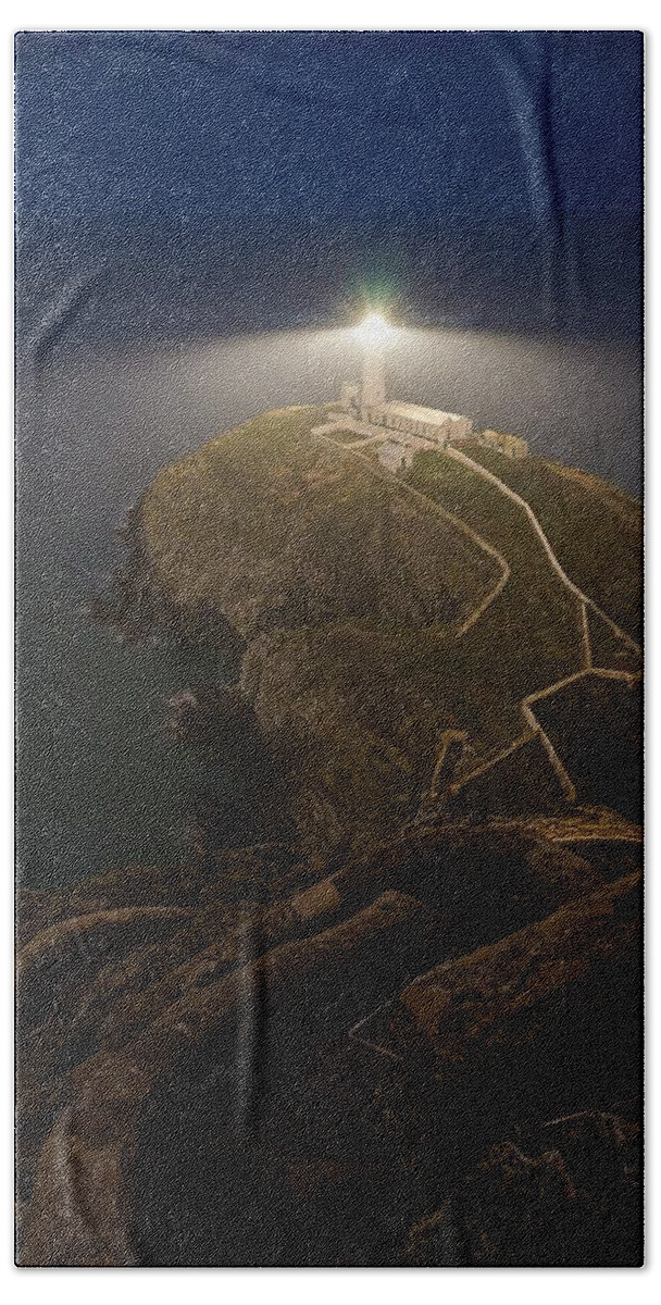 South Stack Beach Towel featuring the photograph South stack lighthouse in Wales seen at night by George Afostovremea