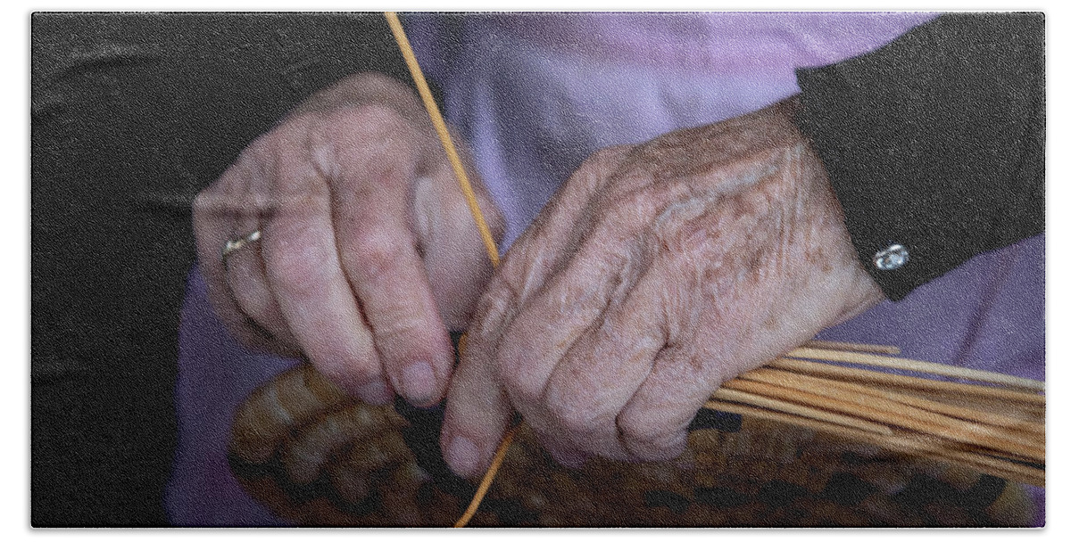 Knitting Beach Towel featuring the photograph Senior woman knitting a traditional basket with reeds  by Michalakis Ppalis