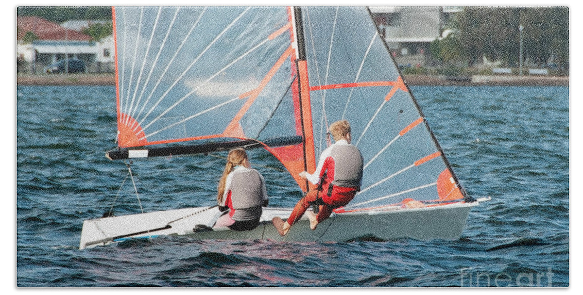 Csne55b Beach Towel featuring the photograph High school students Sailing small sailboat in competition on a by Geoff Childs