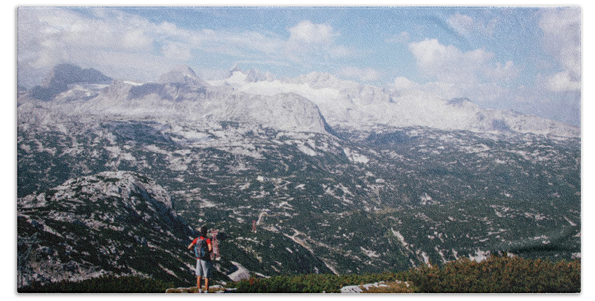 Sportive Beach Towel featuring the photograph Man with a backpack looks at the Dachstein massif by Vaclav Sonnek