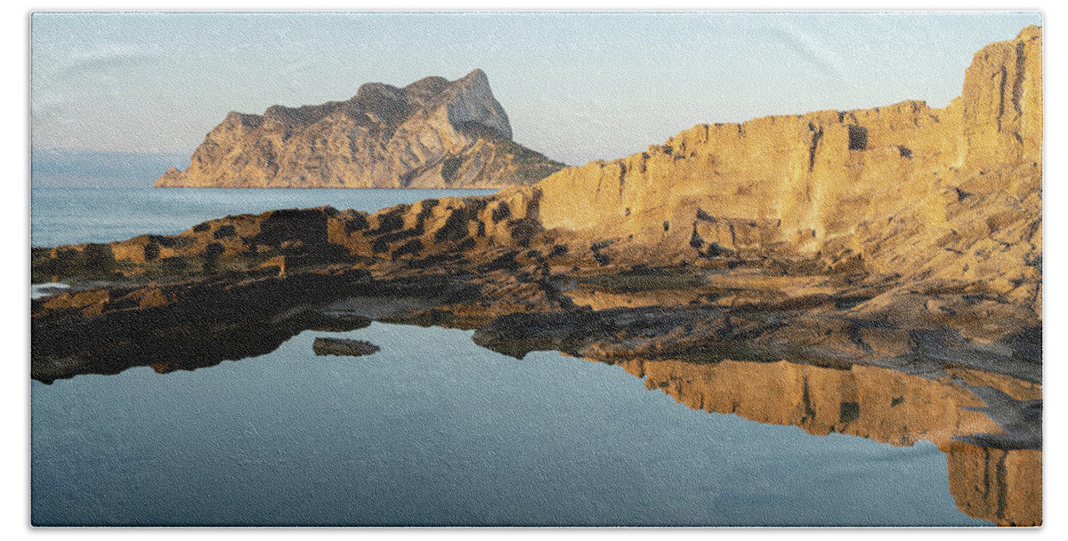 Mediterranean Beach Towel featuring the photograph Reflection of rocks in the calm Mediterranean Sea at sunrise 2 by Adriana Mueller