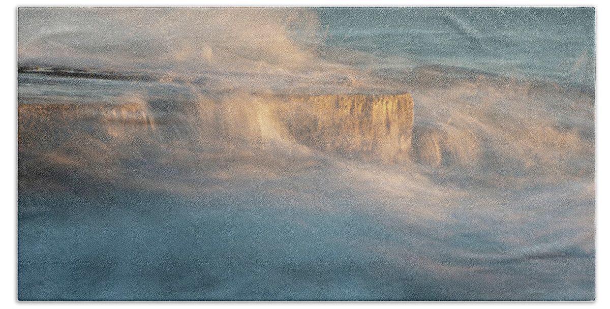 Stormy Sea Beach Towel featuring the photograph Stormy windy sea waves splashing on a rocky seashore at sunset by Michalakis Ppalis