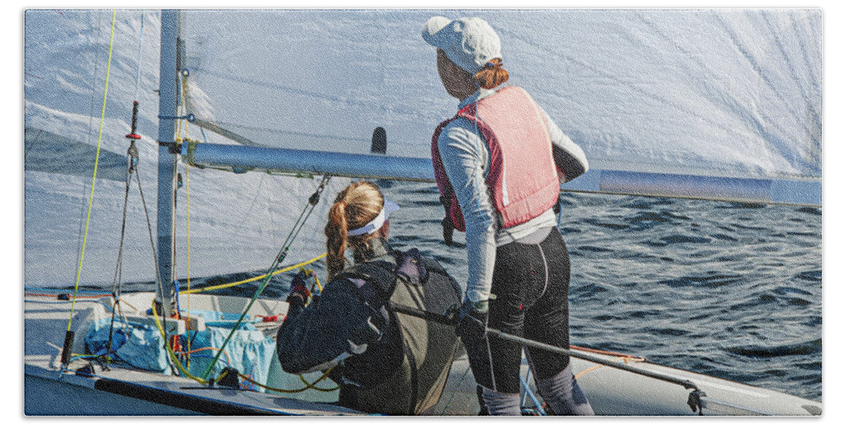 Female Beach Towel featuring the photograph Two girls one standing other sitting sailing a racing skiff clos by Geoff Childs