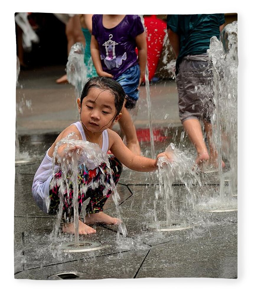 Girl Fleece Blanket featuring the photograph Clothed children play at water fountain by Imran Ahmed