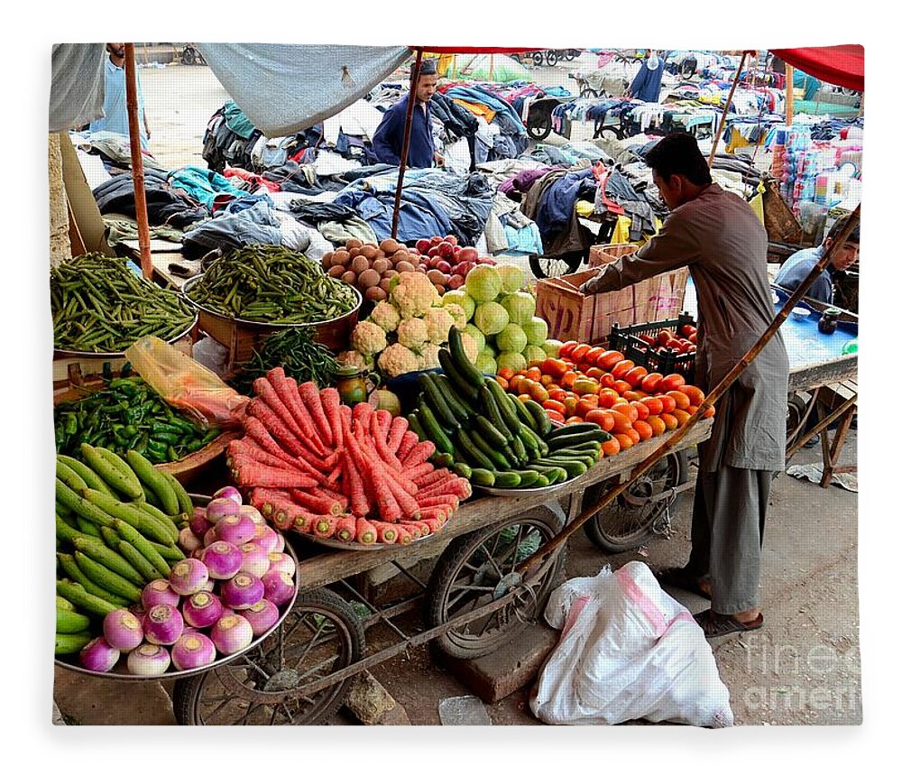 Fruits Fleece Blanket featuring the photograph Fruit and vegetable seller tends to his cart outside Empress Market Karachi Pakistan by Imran Ahmed