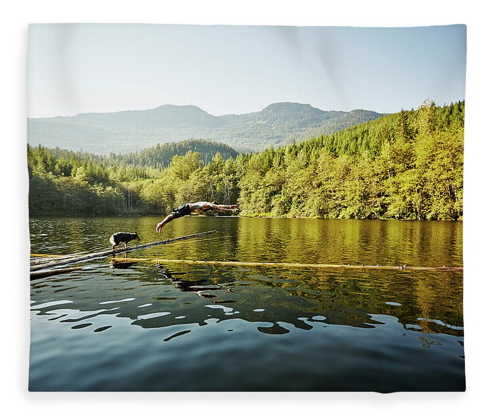 Pets Fleece Blanket featuring the photograph Man Diving Off Log Into Alpine Lake Dog by Thomas Barwick