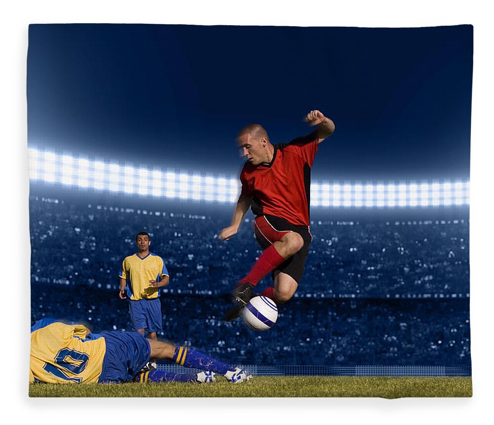 Expertise Fleece Blanket featuring the photograph Soccer Player Jumping With Ball by Kycstudio
