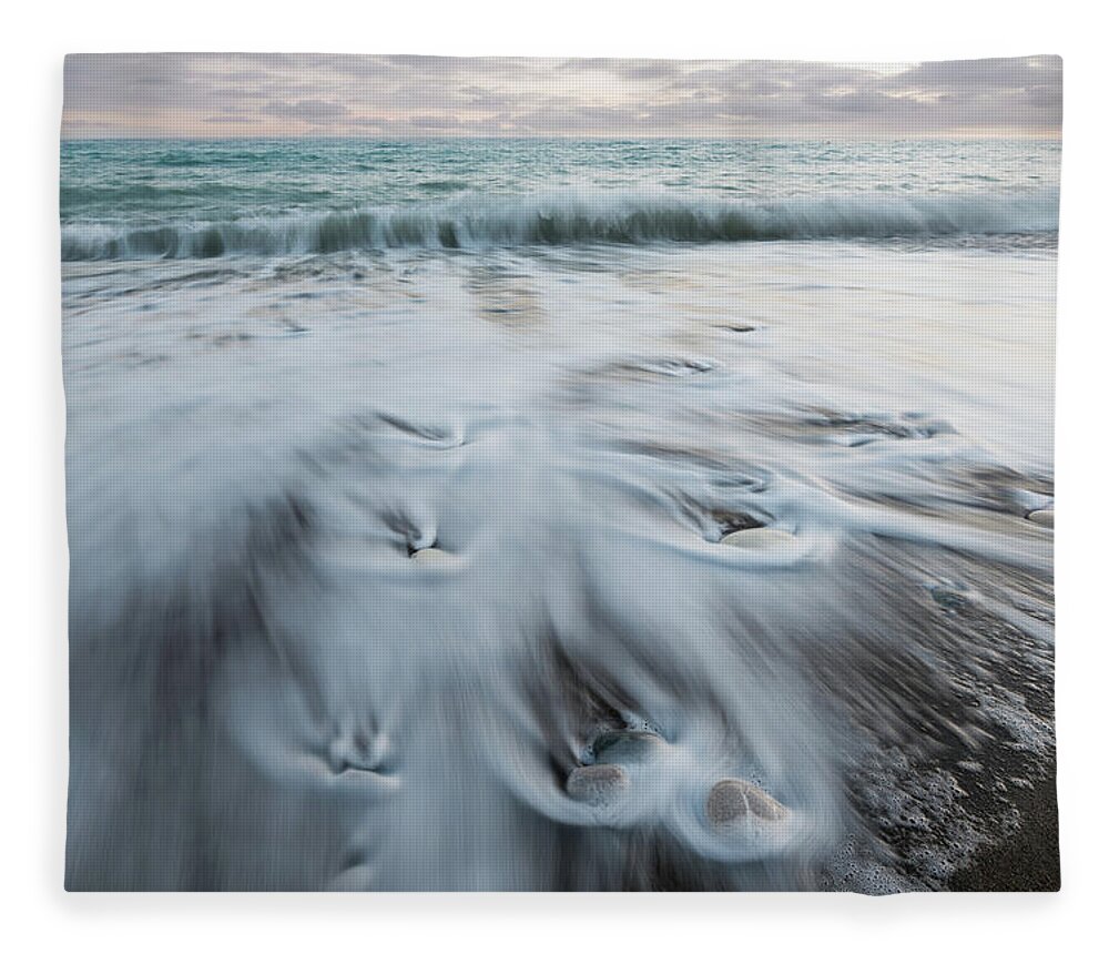 Coastline Fleece Blanket featuring the photograph Pebbles in the beach and flowing sea water by Michalakis Ppalis