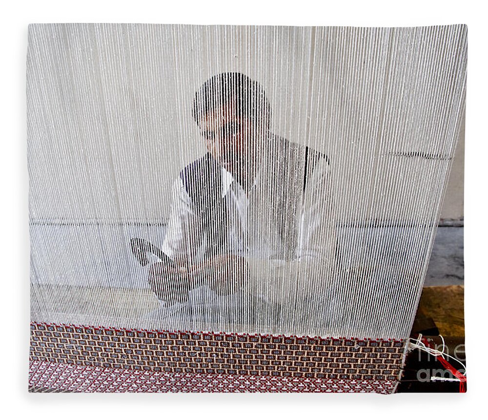 Carpet Weaving Fleece Blanket featuring the photograph A weaver weaves a carpet. by Elena Perelman