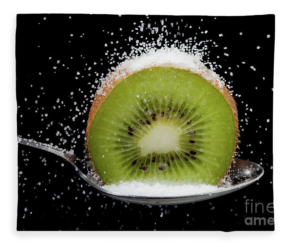 Kiwi Fleece Blanket featuring the photograph Kiwi fruit cut in half on a spoon with sugar by Simon Bratt