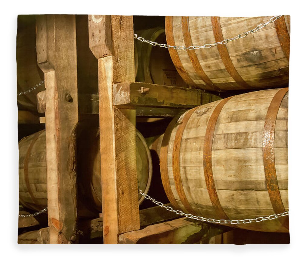 Aging Fleece Blanket featuring the photograph Oak bourbon barrels on rack in warehouse by Karen Foley
