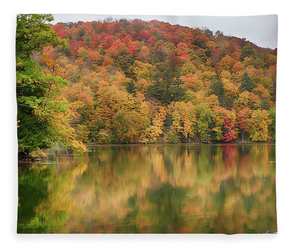 Abenaki Fleece Blanket featuring the photograph Vermont fall foliage reflected on Pogue Pond by Jeff Folger