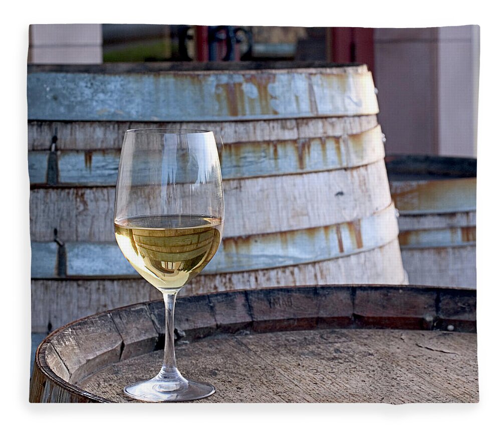 Alcohol Fleece Blanket featuring the photograph A Glass Of Chardonnay Sitting On A by Swalls