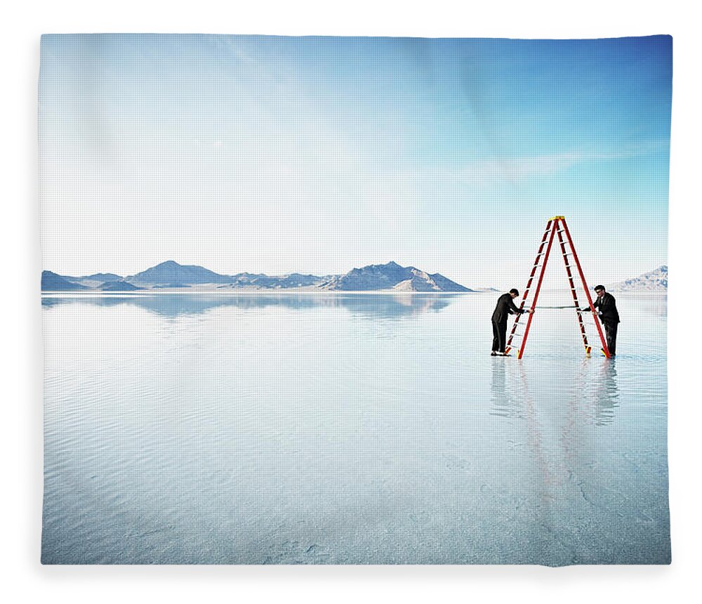 Scenics Fleece Blanket featuring the photograph Businessmen Setting Up Ladder Together by Thomas Barwick