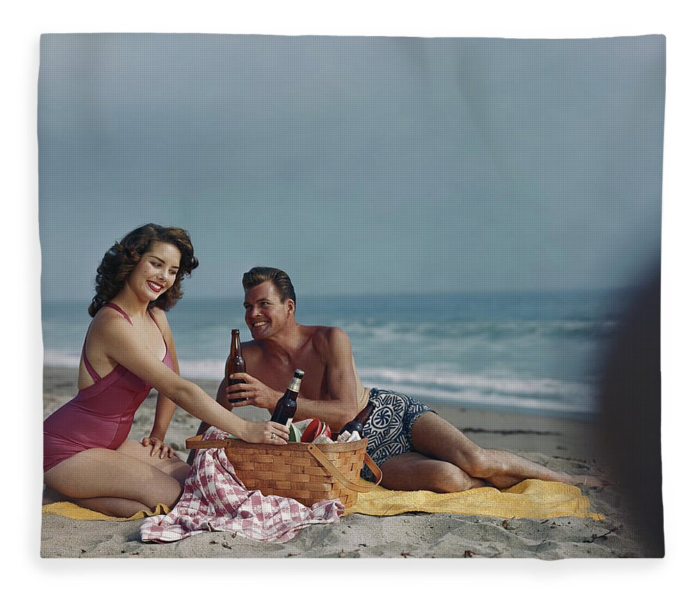 Heterosexual Couple Fleece Blanket featuring the photograph Couple Sitting On Beach Holding Beer by Tom Kelley Archive