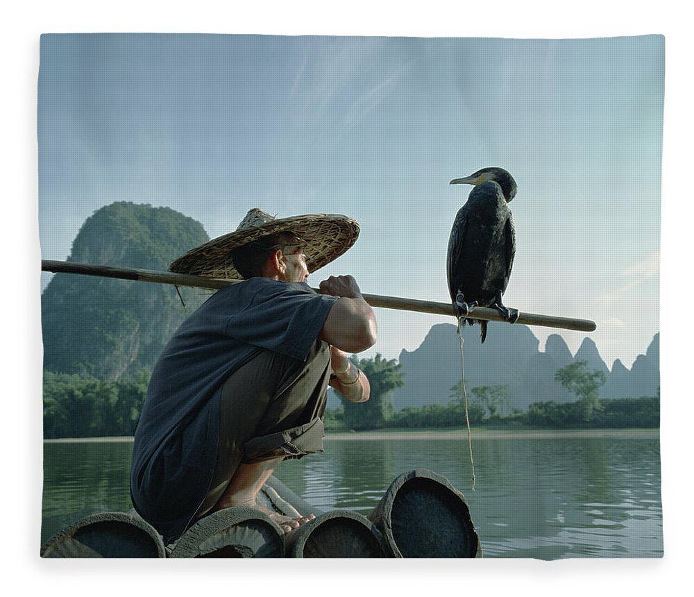 Chinese Culture Fleece Blanket featuring the photograph Fisherman Sitting On Bamboo Raft With by Martin Puddy